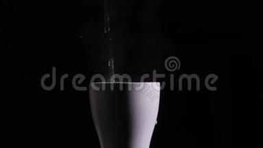 热开水倒入白色陶瓷杯或黑色背景上的杯子。