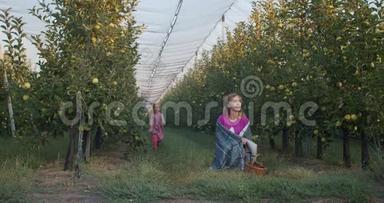 可爱的<strong>一家人</strong>在苹果园，<strong>女儿</strong>正在摘苹果，抱着妈妈