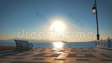 长凳和一盏灯在海湾和<strong>背景</strong>，<strong>大海</strong>和太阳面对相机在黎明。