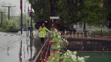 <strong>快乐</strong>的女孩穿着亮黄色的外套，带着雨伞，在雨天穿<strong>过</strong>安纳西的一条运河穿<strong>过</strong>大桥