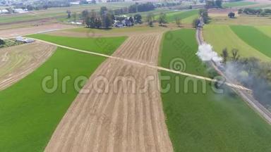 一台老式的蒸汽机经过农田吹烟和蒸汽的空中景色