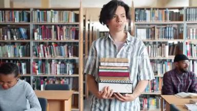 一个严肃的十几岁男孩在<strong>图书馆</strong>里走来走去，一堆书到处看