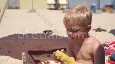 <strong>夏天</strong>，在<strong>炎热的</strong>天气里，小金发男孩在海滩上吃甜玉米。