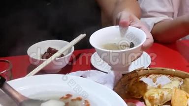 <strong>中餐厅</strong>内人们在碗上倒白蘑菇和枸杞汤的动作