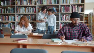 在图书馆工作的大学生使用笔记本电脑聊天阅读书籍