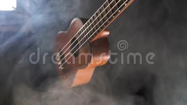 <strong>红木</strong>夏威夷四弦琴吉他在黑色背景下与烟雾隔离