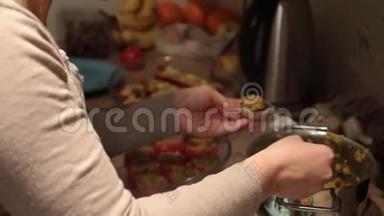 女孩做填好的西红柿。 特写镜头，在乡村厨房的背景上看得见的手