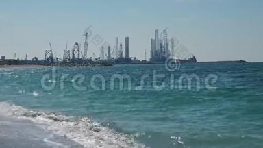 在波斯湾建造石油生产塔。 沙漠化的海滩，海浪。 海洋污染的概念