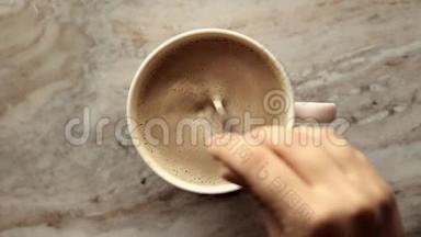 早晨的咖啡杯，牛奶放在大理石石板上，热饮放在桌子上，上面有食物录像和食谱