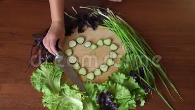 女人把菜刀放在木切割板上，上面有<strong>切片</strong>的<strong>黄瓜</strong>。