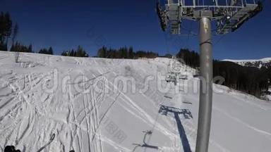 从滑雪椅电梯到雪滑坡，滑雪者在滑雪坡上滑行。 滑雪胜地
