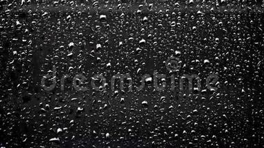 在雨天，深色背景的窗户上有水印，玻璃上有水滴