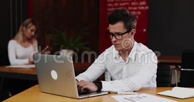 工作压力。年轻的商人在办公室里用笔记本电脑工作看起来<strong>很累</strong>。业务、人员、文书和