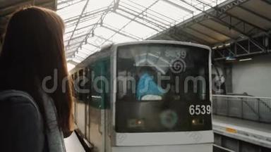 年轻的高加索女人在巴黎<strong>火车</strong>站等地铁列车，<strong>火车</strong>正向站台缓慢<strong>行驶</strong>。