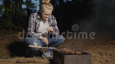 小女孩吃用烧烤火的木棍做的热<strong>棉花糖</strong>。 少女们烤<strong>棉花糖</strong>