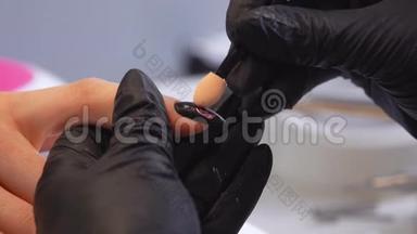 一位美甲师用双手涂上时尚的指甲颜色