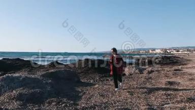 忧郁悲伤的女人穿着格子红色衬衫走在空海的岸边。 年轻孤独的女人一个人呆在海滩上。 悲观主义