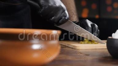 美味的<strong>菜肴</strong>。 厨师在木切割板上切片原料，并在碗中混合。 慢动作。 厨师烹饪