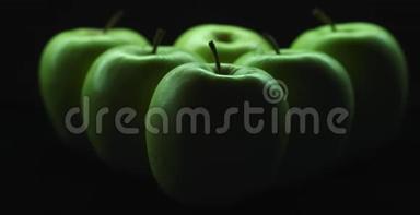 六个绿色的苹果在黑暗的背景，移动的光和阴影。 6K射中红色