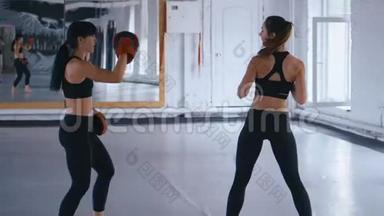 两个身穿黑色健身服的女运动员正在进行一对，<strong>训练</strong>踢腿。 女足运动员<strong>训练比赛</strong>