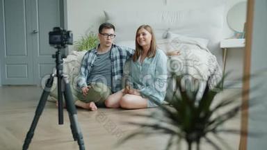 女孩和男孩vloggers为vlog重新编码视频，显示拇指向上在家交谈