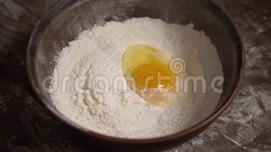 鸡蛋的慢镜头落在碗里和面粉。