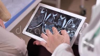 医生拿着平板电脑在屏幕上进行脑部扫描