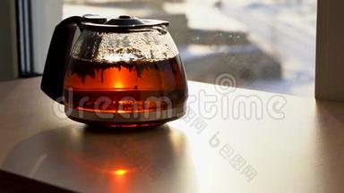 一个茶壶，茶是用透明的玻璃在朝阳的照射下制成的. 在玻璃茶壶里漂浮的红茶颗粒，