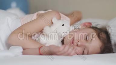 一个熟睡的小女孩的肖像。 漂亮的孩子和玩具睡觉。