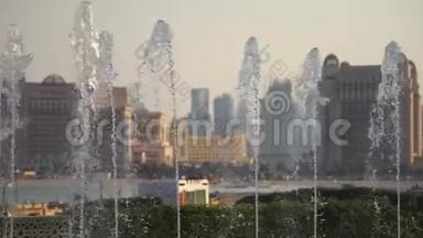 模糊的视野，一个<strong>城市</strong>与慢运动喷泉在前景。 拍摄于<strong>卡塔尔</strong>多哈阳光明媚的一天