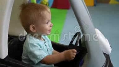 慢动作。 玩具车中的儿童舵轮。 儿童€™的游戏中心。 男孩开玩具车