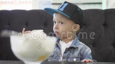 可爱快乐的小男孩在咖啡馆里吃冰淇淋。 小金发幼儿在自制的<strong>冰淇淋杯</strong>里吃冰淇淋