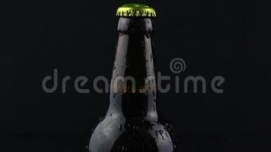 凝结水滴在黑暗的背景下从啤酒瓶中流出。 一瓶雾蒙蒙的啤酒。