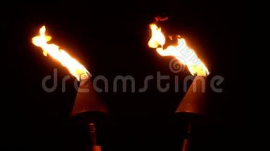 两个现代的Tiki火炬在夜间燃烧