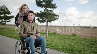 金发女人和她的残疾男友在户外滚动轮椅