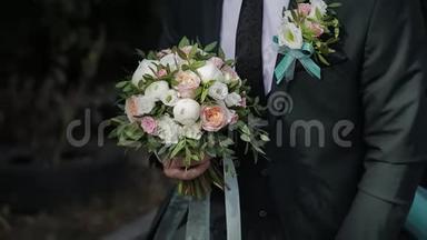 结婚当天带着结婚花束的快乐男人。
