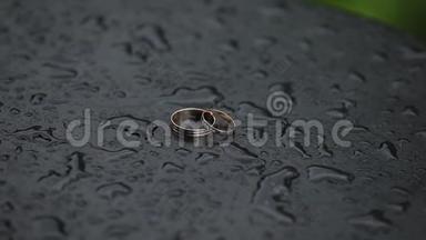 美丽的<strong>金色</strong>结婚戒指在潮湿的表面与<strong>水滴</strong>。