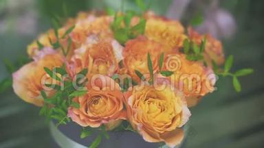 在<strong>花店</strong>橱窗里特写一束<strong>新鲜</strong>的橙色玫瑰和绿色植物