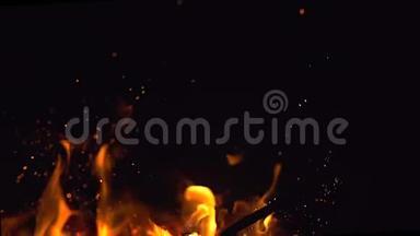 火苗和许多明亮的火花在夜间缓慢地从火中飞来