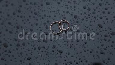美丽的<strong>金色</strong>结婚戒指在潮湿的表面与<strong>水滴</strong>。