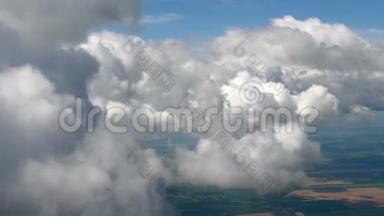 在一架飞机上飞过蓬松的雪白的云层.. 从飞机的窗户可以看到壮观的景色。 飞机飞行