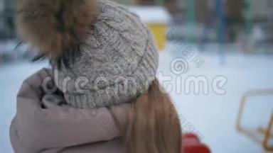 在白雪皑皑的城市里，戴着冬帽和夹克的开朗的女孩在<strong>四处</strong>张望。 合上幸福的脸笑的少年女孩