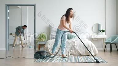 女孩和男人在家里用吸尘器和拖把打扫地板，做家务