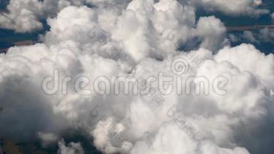 在一架飞机上飞过蓬松的雪白的云层.. 从飞机的窗户可以看到壮观的景色。 飞机飞行