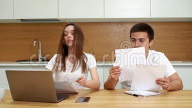 年轻夫妇管理财务，用手提电脑查看银行账户