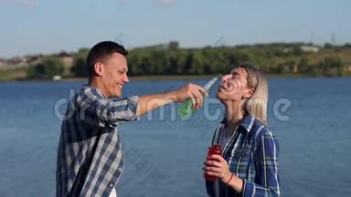 年轻人<strong>喝酒</strong>精饮料，嘲笑湖的背景。
