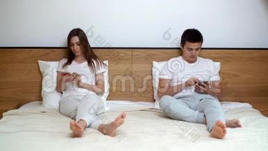 年轻夫妇用电话。 两个人完全专注于他们的智能手机