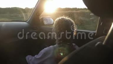 年轻的小女孩在看着车窗外享受这次旅行。 那个女孩正向窗外看。 后景。