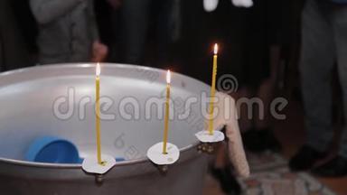 在东正教教堂用燃烧的蜡烛洗礼婴儿的字体。