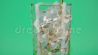 将<strong>可乐倒</strong>入装有冰块的玻璃杯中，置于绿色背景下，特写镜头对准红色